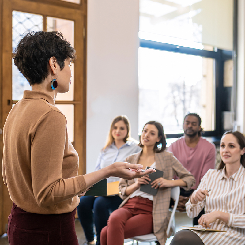 Woman standing up training other people